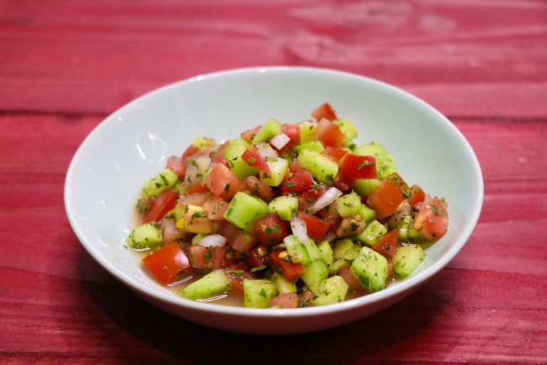 Tomato and cucumber salad in a white bowl